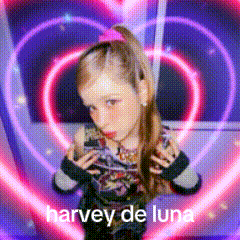 a girl is standing in front of a heart with the words harvey de luna written on it