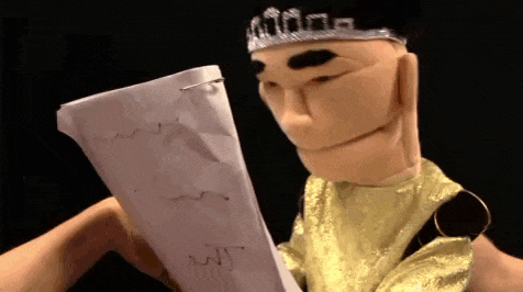 a puppet is holding a piece of paper that says wit on it