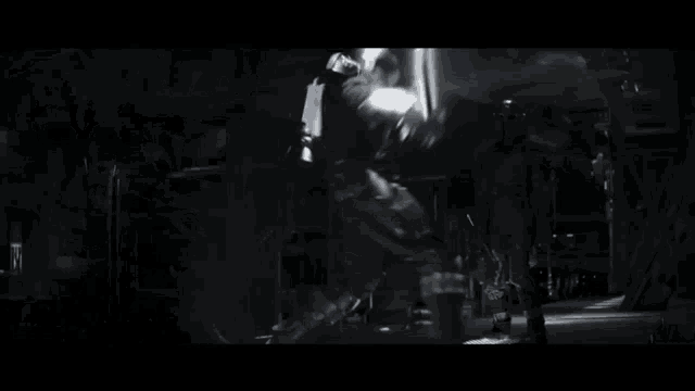 a blurred image of a person in a dark room with a light shining on them