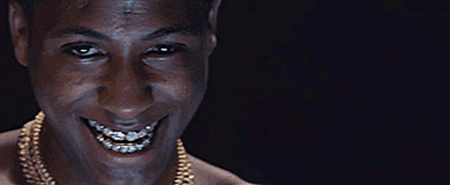 a shirtless man with braces on his teeth is smiling