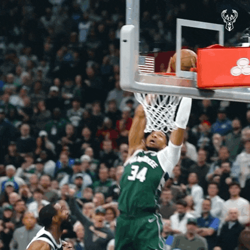 a basketball player wearing a green jersey with the number 34 on it goes up for a dunk