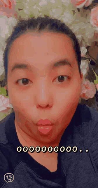 a close up of a woman 's face with flowers in the background and the words 000000 on the bottom right