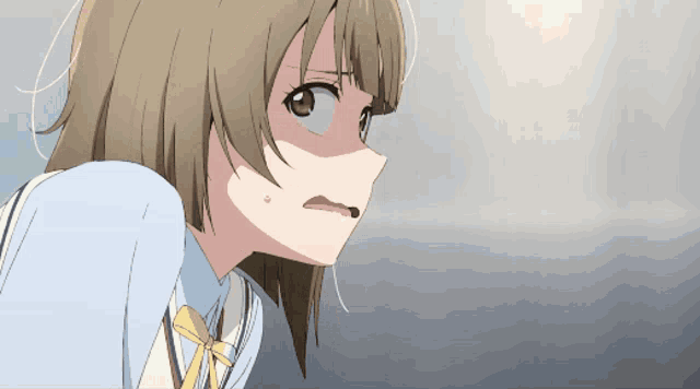 a close up of a girl with brown hair and a blue shirt