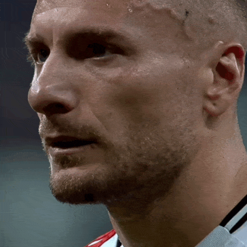 a close up of a man 's face with sweat coming out of his forehead