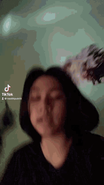 a blurry picture of a woman 's face with a tiktok logo in the corner .