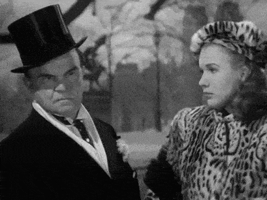a man in a top hat is talking to a woman in a leopard print coat