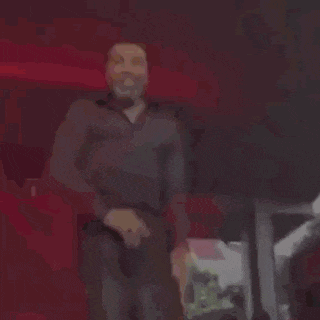 a man is dancing on a stage while holding a microphone .