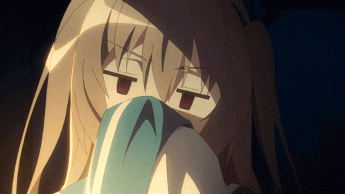 a close up of a girl covering her face with a cloth