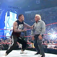two men in a wrestling ring with one wearing a black shirt that says ' heavy weight ' on it