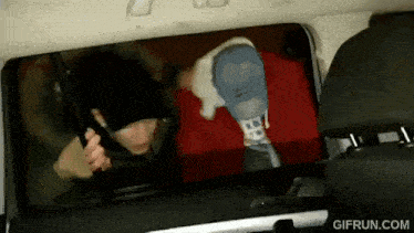 a gif from gifrun.com shows a person sitting in the back seat of a vehicle