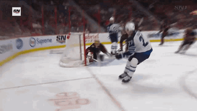 a hockey game is being played in front of a sign that says supreme