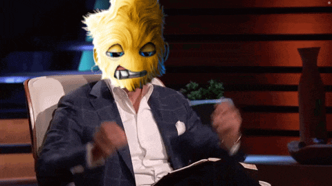a man with a yellow mask on his face is sitting in a chair