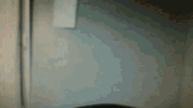 a person is sitting in a chair in front of a wall in a dark room .