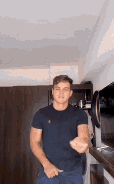a man in a black t-shirt is standing in a room .