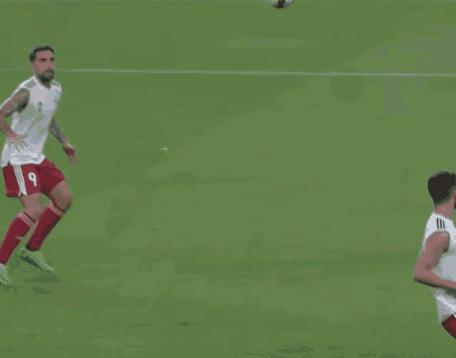 a soccer player with the number 9 on his jersey is kicking the ball