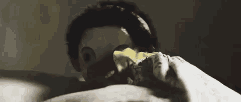 a person wearing a mask with an eagle 's beak is laying in bed .