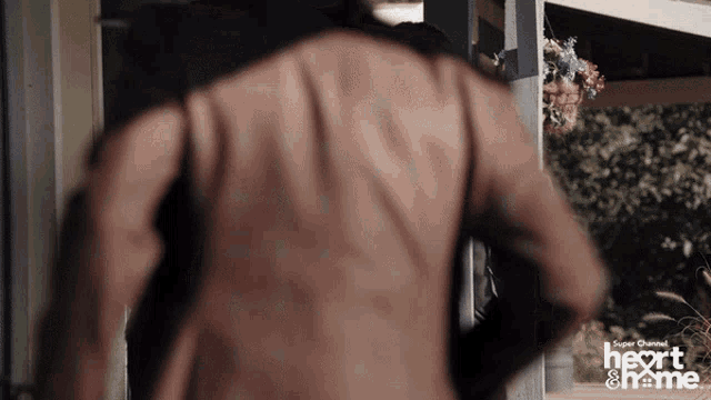 a man 's back is shown in a super channel ad for heart & me