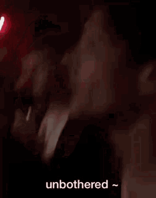 a group of people are standing in a room with red lights and talking .