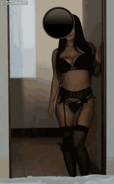 a woman in lingerie is standing in front of a mirror in a bedroom .