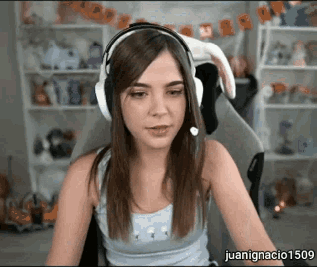 a woman wearing headphones is sitting in a chair with the name juanignacio 1509 on the bottom