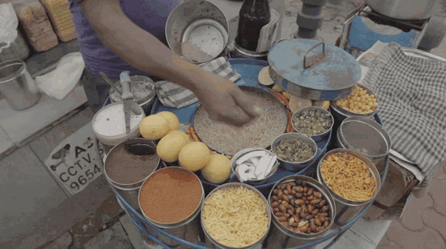 a person is preparing food in front of a sign that says cctv 9654