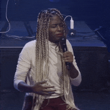 a woman with braids singing into a microphone with the word sennheiser on it