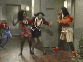 three women are dancing in a hallway in front of a sign that says no smoking