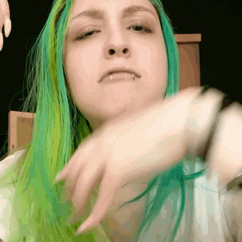 a woman with green hair has a piercing in her nose