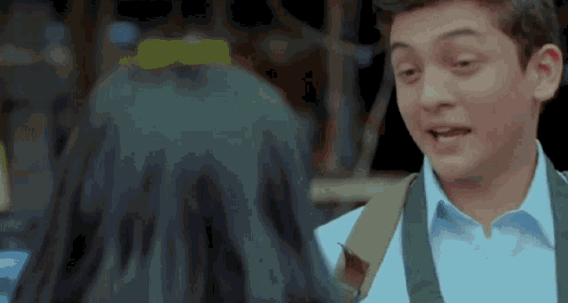 a man and a woman are talking to each other . the man is wearing a backpack .
