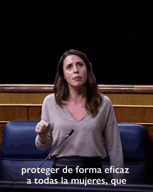 a woman speaking into a microphone with the words proteger de forma eficaz a todas la mujeres que behind her