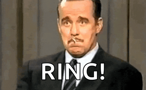 a man in a suit and tie is smoking a cigarette and making a funny face .