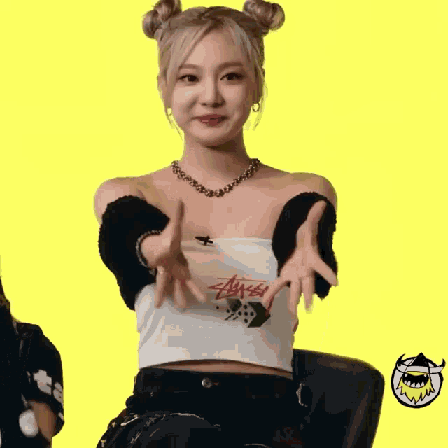 a woman wearing a stussy t-shirt is giving a peace sign