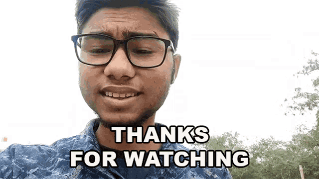 a man wearing glasses and a blue shirt says thanks for watching
