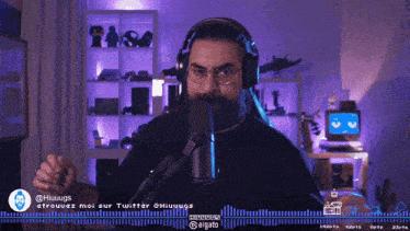 a man wearing headphones stands in front of a microphone with a purple background behind him