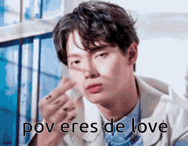 a man in a suit is giving a middle finger and the words pov eres de love are written below him .