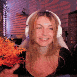 a woman wearing headphones is smiling in front of a window .