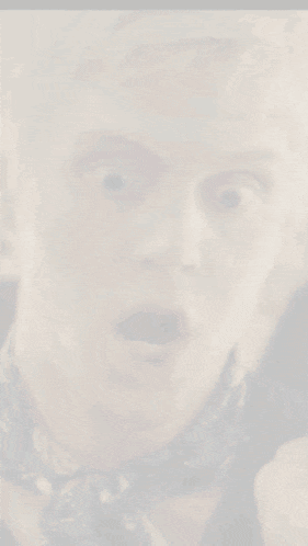 a man with blonde hair and a blue scarf making a funny face