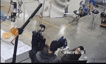 a camera is pointed at a group of people in a warehouse