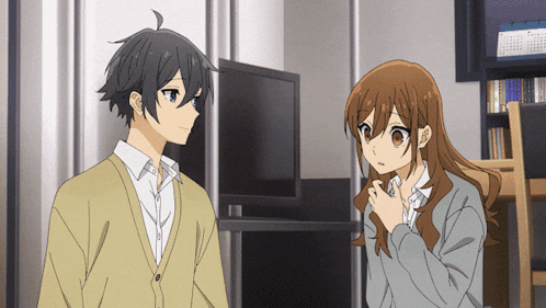 a boy and a girl are talking in front of a television