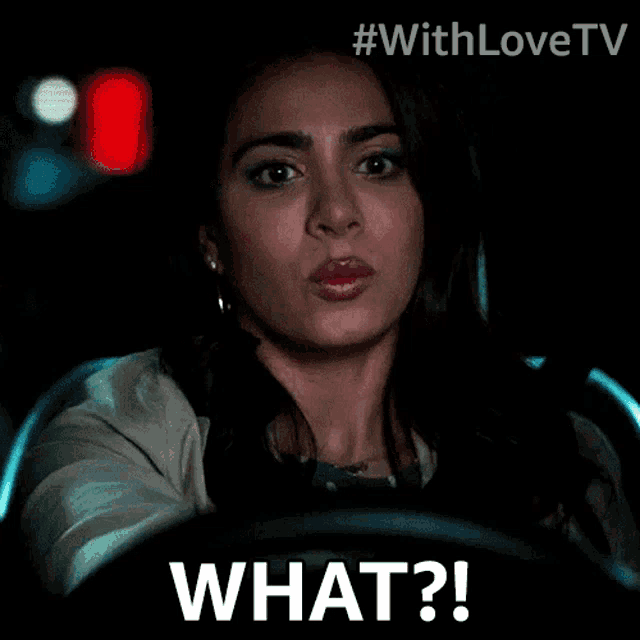 a woman driving a car with the words what written on her face