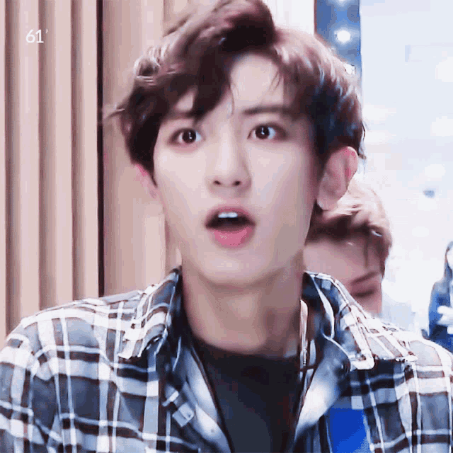 a man wearing a plaid shirt with the number 61 on the bottom right