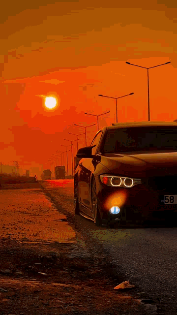 a car with a license plate that says 58 is parked on the side of a road at sunset