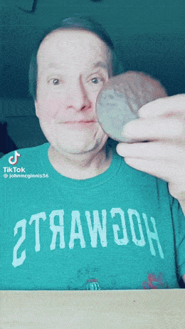a man wearing a green shirt that says ' 2trawooh ' on it