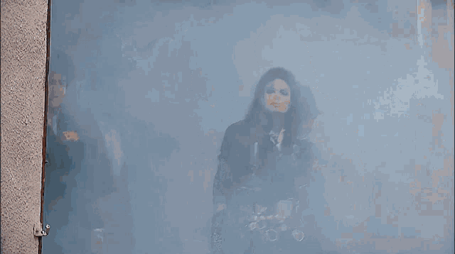 a group of men are standing in a room with smoke coming out of the door
