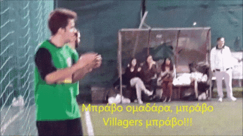 a man in a green jersey is standing in front of a soccer net with the words villagers written on it