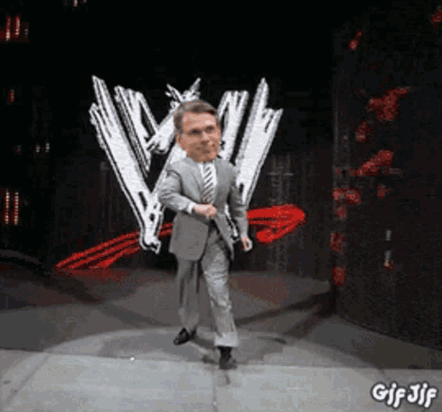 a man in a suit and tie dancing in front of a w logo