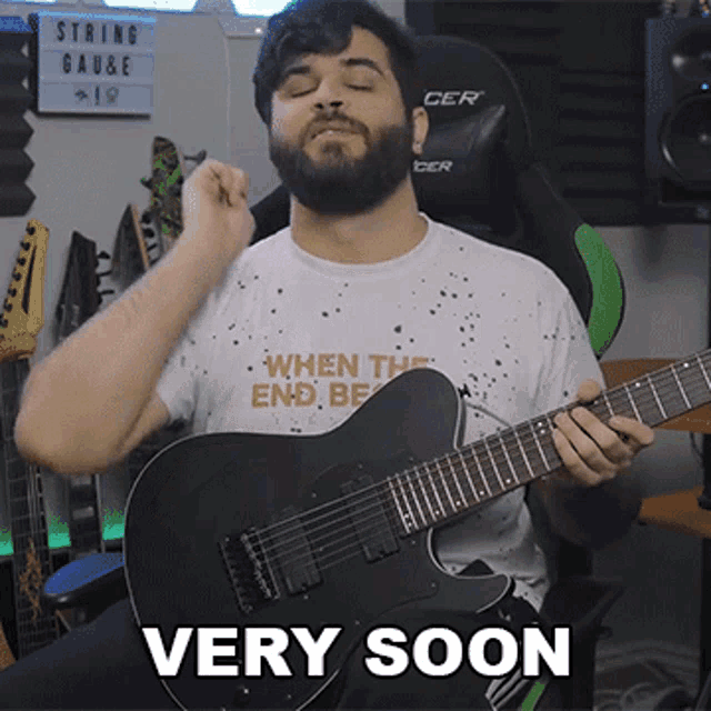 a man playing a guitar with the words very soon written on the bottom