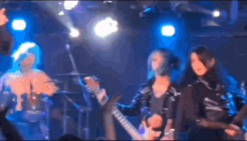 a group of people playing instruments on a stage with blue lights