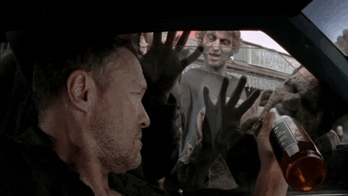 a man in a car with zombies behind him and a sign that says tobacco on it