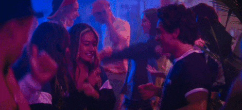 a group of people are dancing in a dark room in a club .
